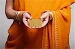 cropped shot of woman wearing sari holding credit card