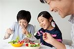 Parents et fille manger salade