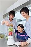 Eltern und Tochter Gemüse Saft machen