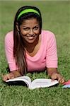 jeune femme portant sur l'herbe en lisant un livre