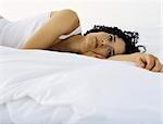 Woman lying on bed daydreaming