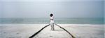 Little boy sulking on beach, arms folded