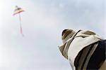 Child watching kite in sky, rear view