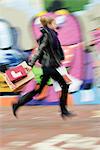 Teenage girl walking with shopping bags, blurred