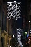 Star-shaped lights hanging along city street at night