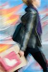 Shopper carrying shopping bags, blurred