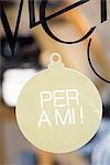Sign shaped like Christmas ornament in shop window, proclaiming "per a mi," ("for me" in Catalan)