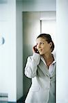 Businesswoman using cell phone, glancing away