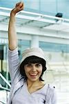 Young woman smiling at camera with one fist raised in air