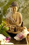 Buddha with incense cone and orchid blossoms