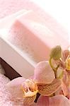 Foamy soap bar decorated with an orchid on a soap dish