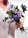 woman holding a bouquet of vetches and forget-me-nots