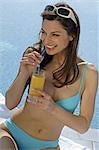 Woman on sunlounger with sunglasses and a drink