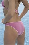 Lower part of the body of a woman in a pink bikini