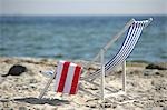 Blaue und weiße Liegestuhl am Strand