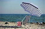 Blue and white sunshade and deckchair on the beach