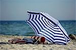 Blaue und weiße Sonnenschirm am Strand