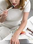 Woman is eating sushi at her desk