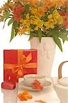 Arrangement of tea pot,a cup of tea,gift and bouquet