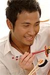 Man eating sushi with chopsticks