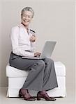 Senior adult with laptop and credit card