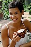 Femme aux cheveux foncée avec tasse cappuccino