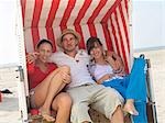 Trois amis dans une chaise de plage en osier