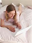 young woman with her laptop in bed