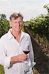 Portrait d'homme en vignoble tenant un verre de vin