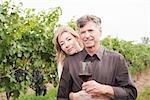Portrait of Couple in Vineyard Holding a Glass of Wine