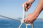 man making knot into rope