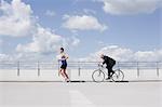 man with bycicle chasing jogger