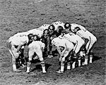 1960s TEAM FOOTBALL HUDDLE