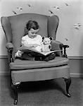 CHILD SITTING ON LARGE CHAIR WITH BEAR READING BOOK