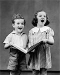 1930s TWO CHILDREN STANDING SINGING