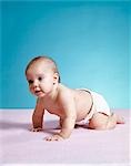1970s BABY WEARING DIAPER CRAWLING ON PINK BLANKET