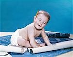 1960s BABY EYES CLOSED FUNNY FACIAL EXPRESSION CRAWLING ON ROLLING OUT BLUEPRINTS