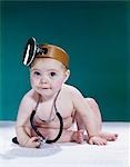 1960s BABY MAKING FUNNY FACE WEARING MEDICAL DOCTOR OPTHALMOSCOPE AND STETHOSCOPE