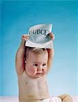 1960s BABY HOLDING BUDGET SIGN ABOVE HIS HEAD