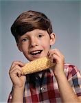 1960s SMILING BOY EATING CORN ON THE COB
