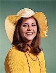 1970s SMILING YOUNG WOMAN WEARING YELLOW FLOPPY BRIM HAT AND BLOUSE WITH PINK BEADS