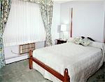 1960s BEDROOM WITH FULL SIZE BED WINDOW WITH FLORAL PRINT DRAPES SHEERS AND AIR CONDITIONER