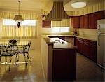 1970s KITCHEN AND DINING AREA WITH YELLOW STRIPED CURTAINS WALLPAPER AND DARK WOODEN CABINETS