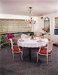 1960s DINING ROOM TABLE CHAIRS PLACES SET FOR FOUR FRINGED TABLECLOTH CHANDELIER AUSTRIAN SHADE WINDOW TREATMENT