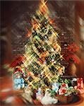 CHRISTMAS TREE WITH DECORATIONS GARLAND LIGHTS TOYS AND PRESENTS UNDER TREE BLURRED EFFECT