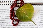 Praying beads with a pipal leaf on a book, Mahabodhi Temple, Bodhgaya, Gaya, Bihar, India