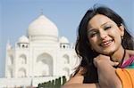 Femme souriant avec un mausolée dans le fond, Taj Mahal, Agra, Uttar Pradesh, Inde