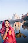 Frau am Flussufer mit Mausoleum im Hintergrund, Taj Mahal, Yamuna River, Agra, Uttar Pradesh, Indien