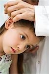 Doctor putting drops in little girl's ear, cropped