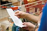 Shopper reviewing receipt, cropped